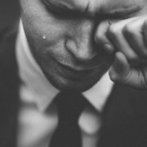 man wiping his tears